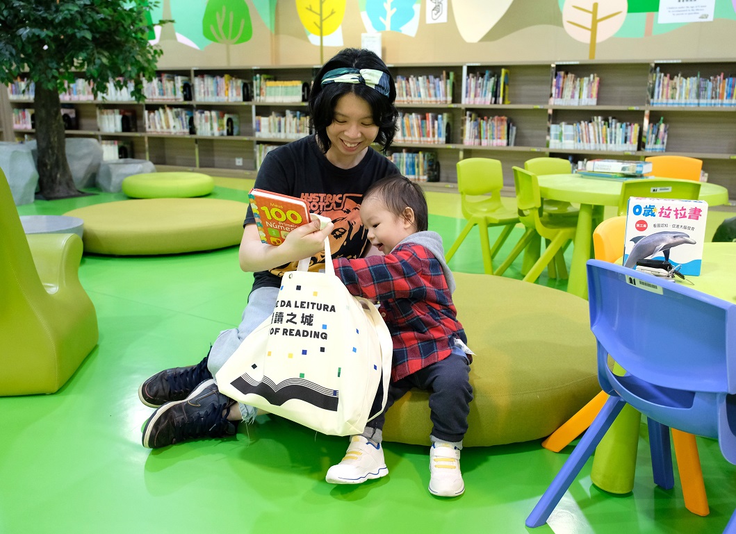 Mel Cheong adds fun to the opening of the "reading pack" by engaging in a "treasure hunt" with her son.
